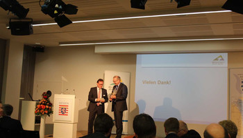 Rhein-Neckar Forum in Brüssel | © VRRN Menschen schauen auf die Bühne zu zwei Männern am Rednerpult | © VRRN