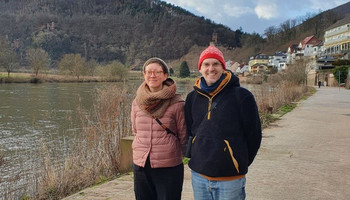 Mia Rushton und Eric Moschopedis | © MRN GmbH Zwei Personen in Winterkleidung stehen nebeneinander an einem Fluss und schauen in die Kamera | © MRN GmbH