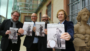Netzwerk der Museen und Schlösser | © MRN GmbH Vier Männer stehen draußen und halten alle das Kulturmagazin in die Kamera | © MRN GmbH