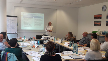 Qualifizierung "Betrieblicher Pflege-Guide" | © MRN GmbH Menschen sitzen an Tischen und hören der Workshoprednerin zu | © MRN GmbH
