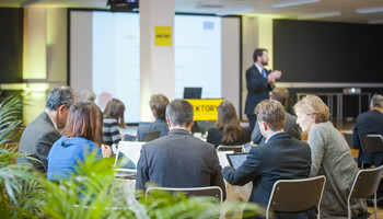 The Once-Only Principle | © MRN GmbH Menschen sitzen an Tischen bei einer Veranstaltung | © MRN GmbH